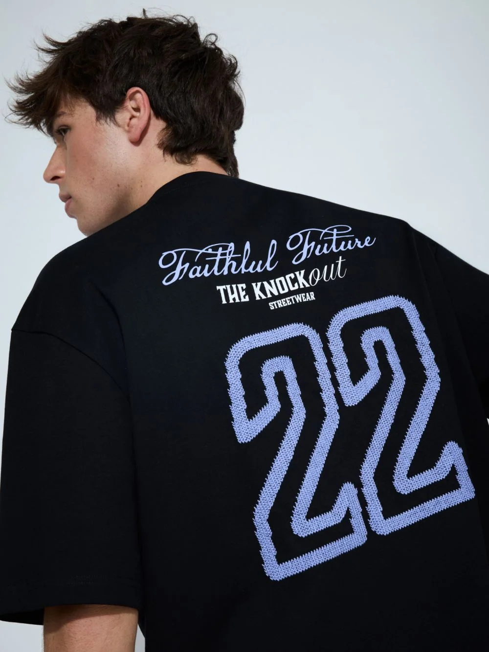גב חולצה שחורה עם הדפס Faithful Future ומספר 22 רקום
